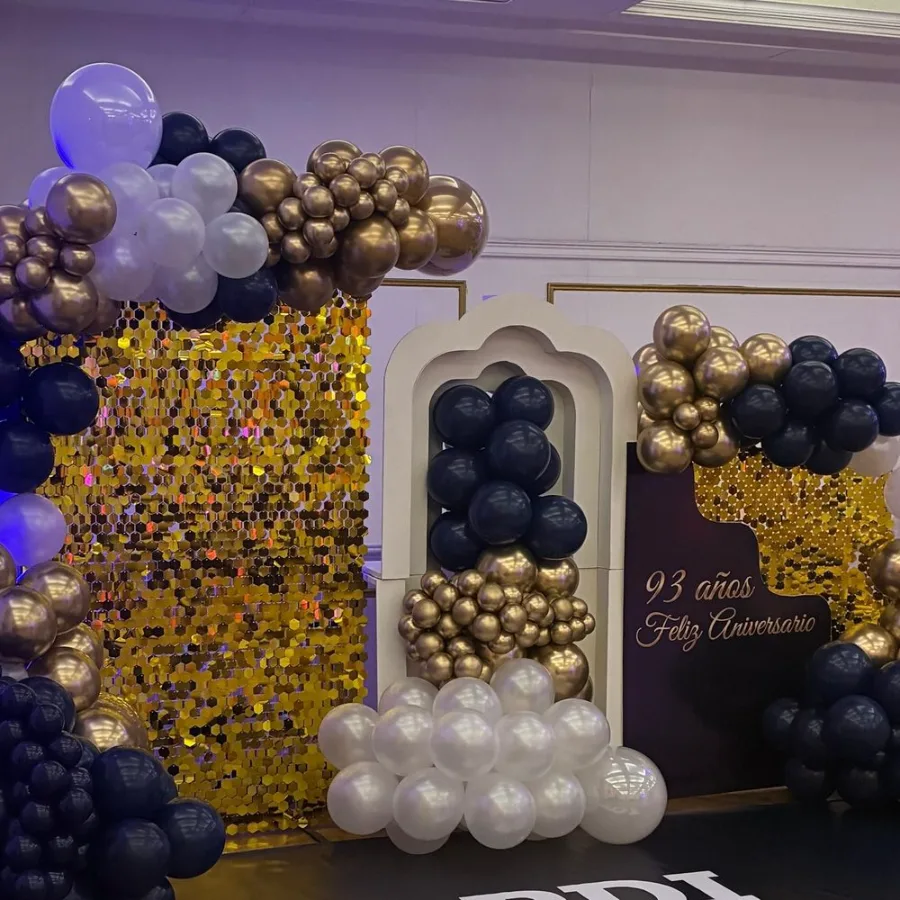 Aniversario 93 años, decoración elegante en negro y dorado con backdrop de lentejuelas